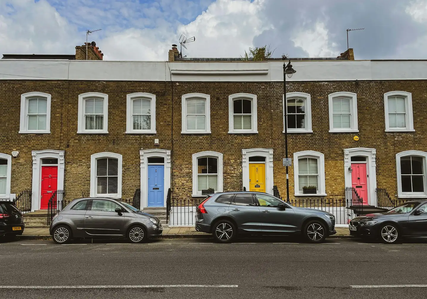 A row of London terraced houses with coloured front doors